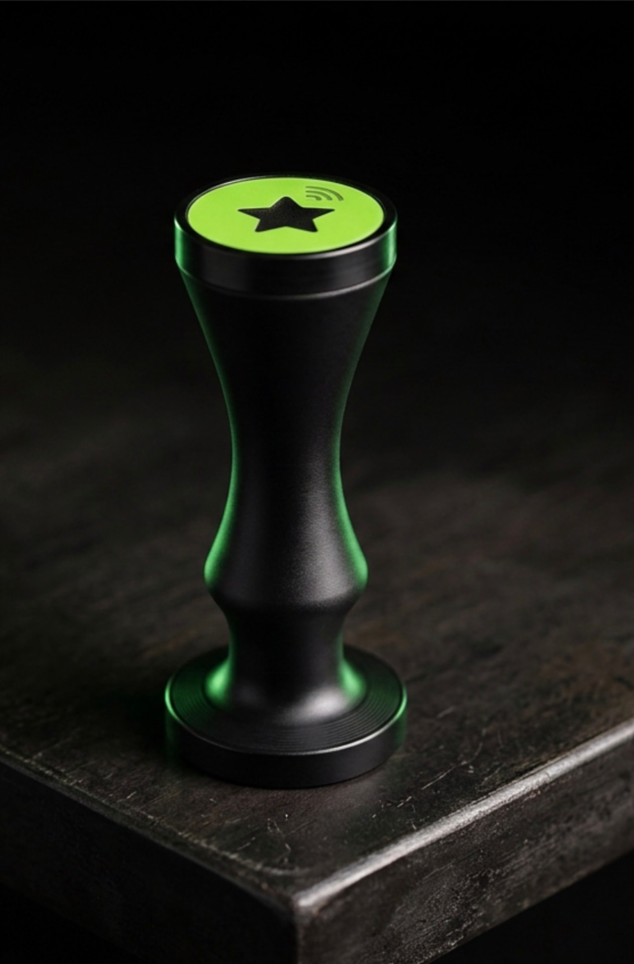 The LoyaltyTap NFC stamp: a black stamp with a green top and a black star, used by staff to add a loyalty stamp to a customer's phone